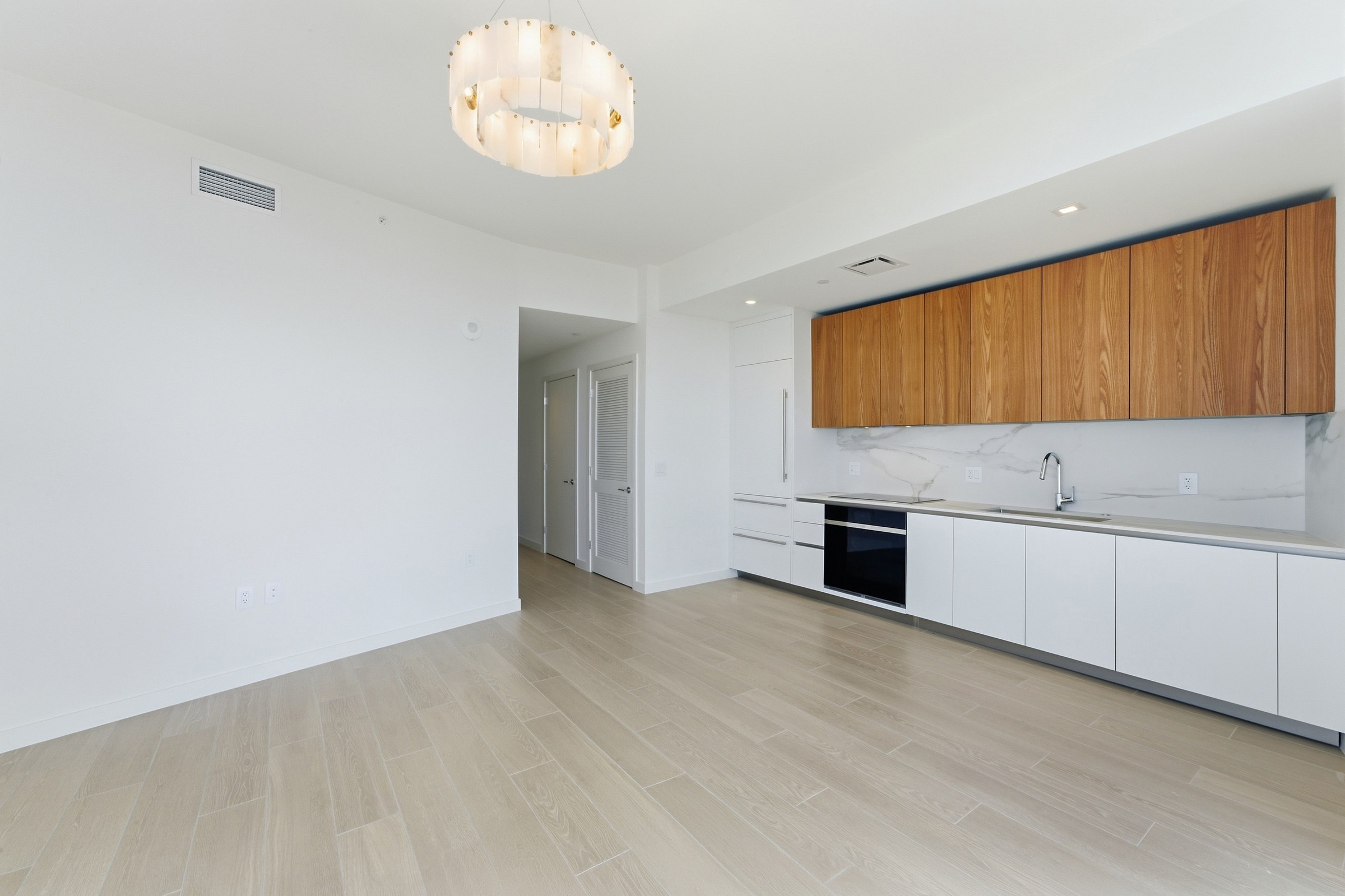 Open-plan kitchen and living area with sculptural pendant light
