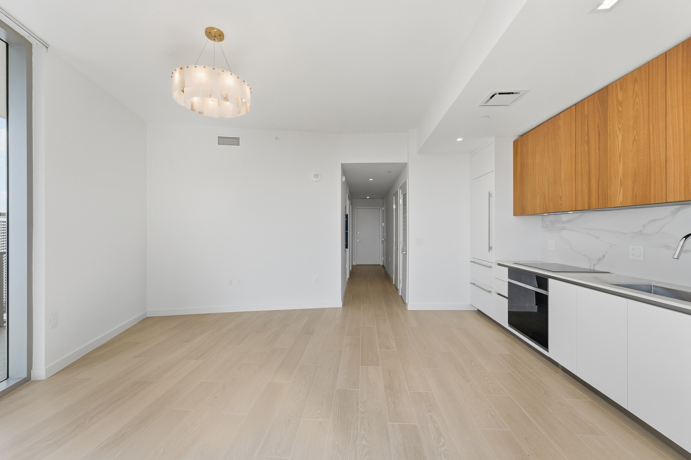 Long interior perspective across the kitchen and living area