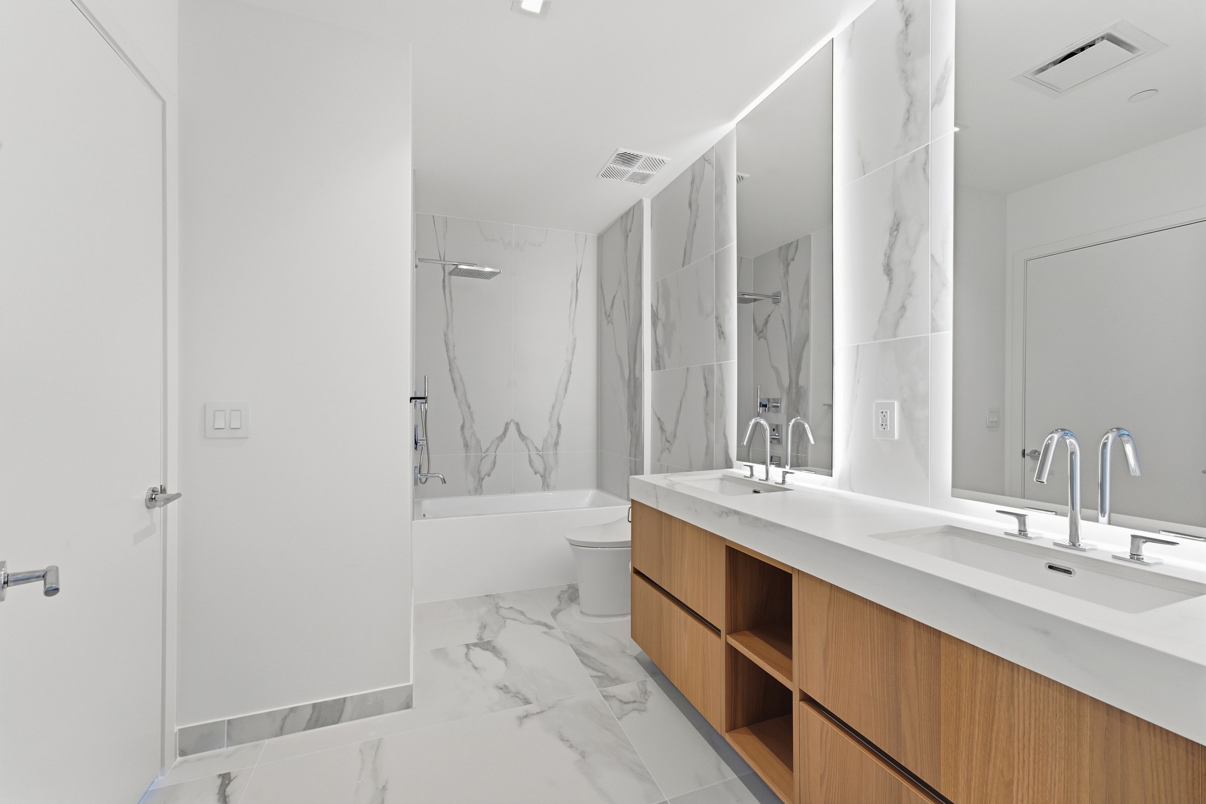 Illuminated mirrors and double vanity in Residence 3007